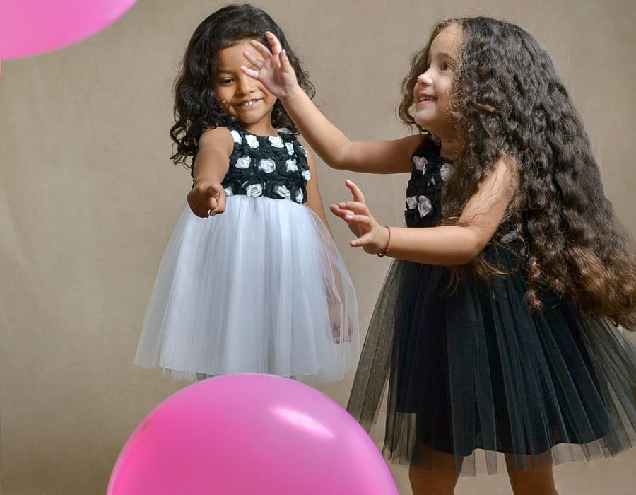 Dos niñas con globos rosados — Lunita Blanca